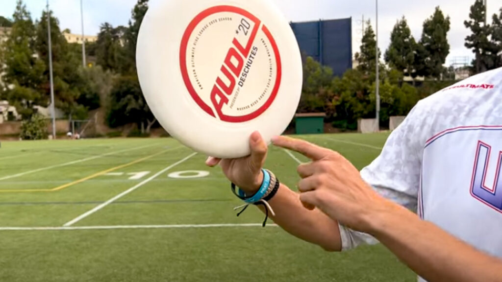 A demonstration of where to place your thumb when throwing and ultimate frisbee forehand